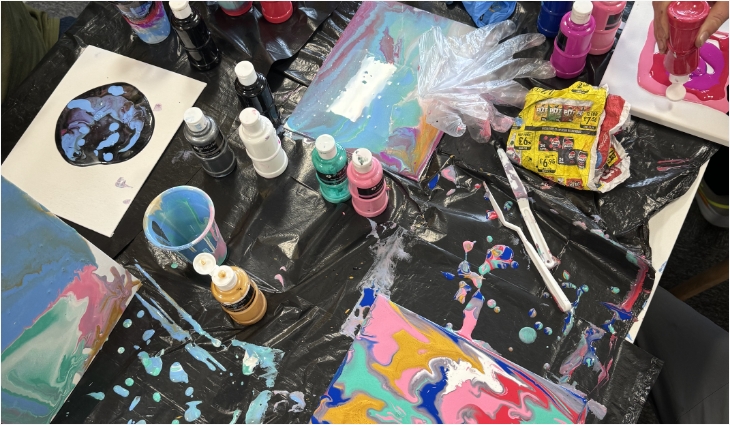 Colourful poured paint, canvases and bottles from a Throw Paint session